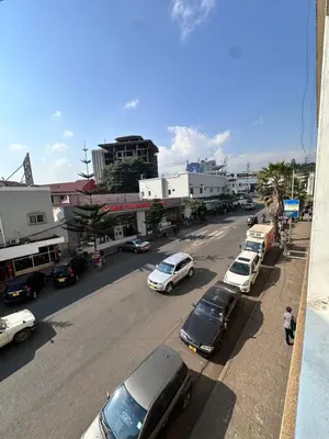 a city street with cars parked on the side of the road at Maya in Arusha