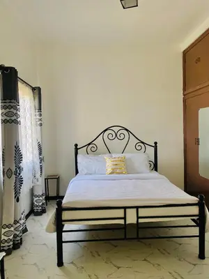 a bedroom with a bed with a black frame at Maya in Arusha