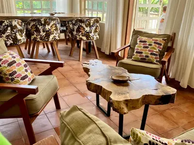 a living room with a wooden table and chairs at Allamanda House Meru in Arusha