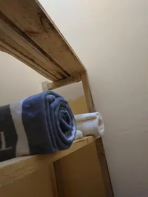 a towel sitting on top of a wooden shelf at Sero Safaris Hostel in Arusha