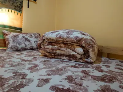 a bed with a comforter and a pillow on it at Sero Safaris Hostel in Arusha