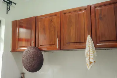 a kitchen with wooden cabinets on the wall at Mesa, Mama Ket Homes Arusha in Arusha