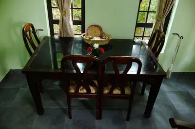 a dining room table with two chairs and a black table at Mesa, Mama Ket Homes Arusha in Arusha