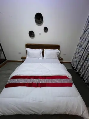 a bedroom with a large bed with red and white sheets at Lavish luxury homes in Nkoanrua