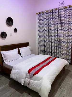 a bedroom with a bed with white sheets and a curtain at Lavish luxury homes in Nkoanrua