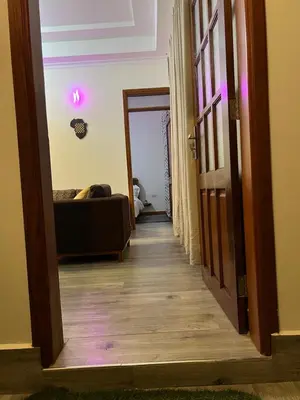 a hallway with a door leading to a room with a couch at Lavish luxury homes in Nkoanrua