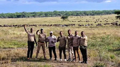a group of men standing in front of a field at Africa Safari Serengeti Kusini in Serengeti National Park