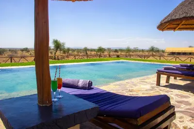 a table with drinks on it next to a swimming pool at Africa Safari Serengeti Kusini in Serengeti National Park