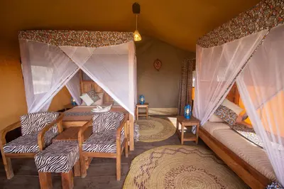 a room with a tent with chairs and a table at Africa Safari Serengeti Kusini in Serengeti National Park