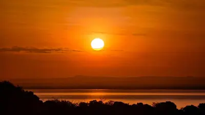 a sunset over a body of water at Africa Safari Rift Valley Camping in Magara