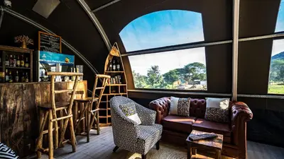 a living room with a couch and some windows at Africa Safari Rift Valley Camping in Magara