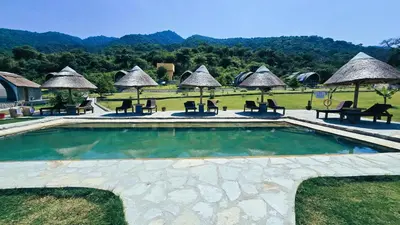 a pool at a resort with chairs and umbrellas at Africa Safari Rift Valley Camping in Magara