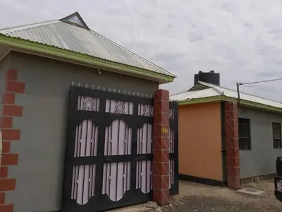 a house with two garage doors in front of it at Dangote Farm House Eyasi in Mangola
