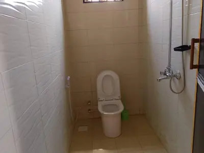 a small bathroom with a toilet in a stall at Dangote Farm House Eyasi in Mangola
