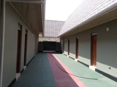 an empty hallway of a building with a red and green carpet at Dangote Farm House Eyasi in Mangola