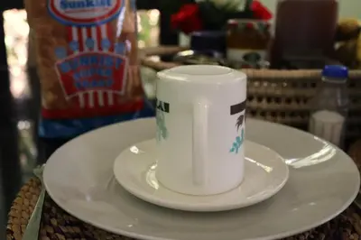 a white cup sitting on a plate on a table at My Moka Arusha in Arusha
