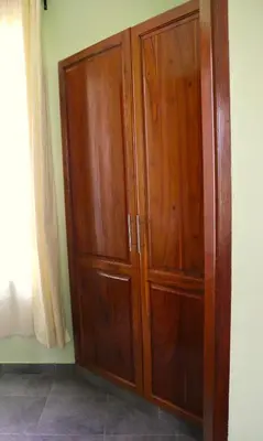 a wooden cabinet in the corner of a room at My Moka Arusha in Arusha