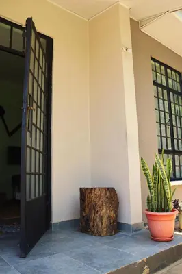 an open door with a tree stump in front of a house at My Moka Arusha in Arusha