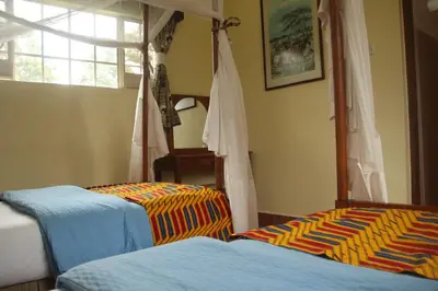 a bedroom with two beds and a bunk bed at Marangu Hotel in Marangu