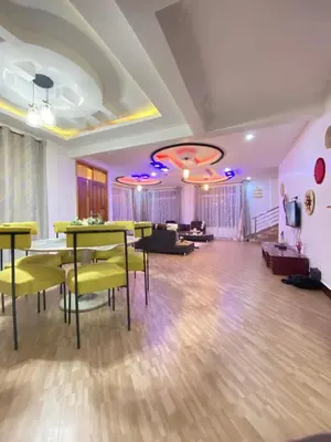 a living room with tables and chairs and a couch at SandS Escape in Arusha
