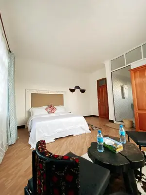 a bedroom with a bed and a table and chairs at SandS Escape in Arusha