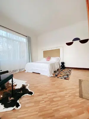 a bedroom with a bed and a wooden floor at SandS Escape in Arusha