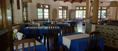 a dining room with blue tables and chairs at Kilimanjaro Lodge Cabins in Moshi