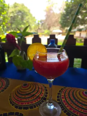 a drink in a glass sitting on a table at Kilimanjaro Lodge Cabins in Moshi