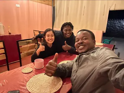 three people sitting at a table giving thumbs up at Shavia Lodge in Arusha