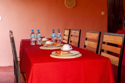 a table with a red table cloth and bottles of water at Shavia Lodge in Arusha