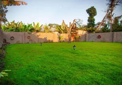 a green yard with two lights in the grass at Shavia Lodge in Arusha