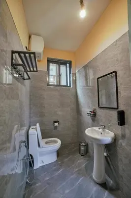 a bathroom with a toilet and a sink at Samora River Lodge in Kioga