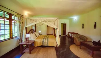 a bedroom with a large bed with a canopy at House of West Kili in Bondeni Boloti