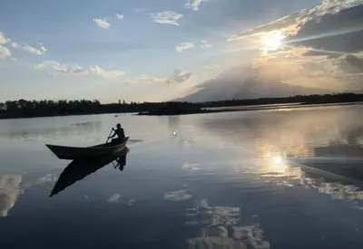 a man is in a boat on a lake at House of West Kili in Bondeni Boloti