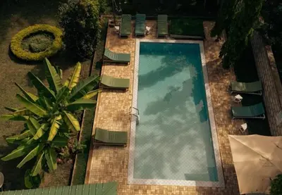 an overhead view of a swimming pool with chairs and a plant at House of West Kili in Bondeni Boloti