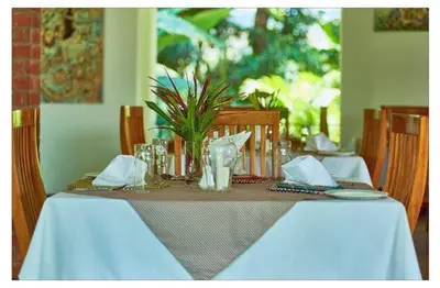 a dining table with a blue table cloth and a vase at House of West Kili in Bondeni Boloti