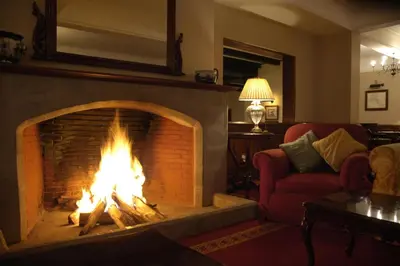 a fireplace in a living room with a fire at Arusha Serena Hotel in Nkoanrua