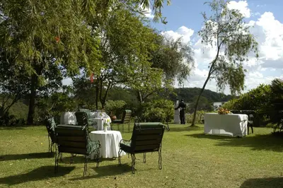 a table and chairs with white table cloths on the grass at Arusha Serena Hotel in Nkoanrua