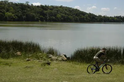 a man riding a bike next to a lake at Arusha Serena Hotel in Nkoanrua