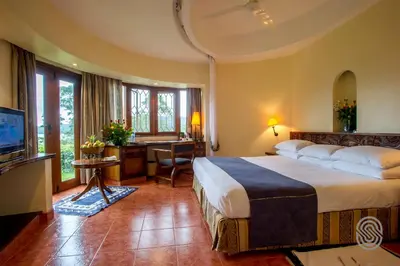 a hotel room with a large bed and a desk at Arusha Serena Hotel in Nkoanrua
