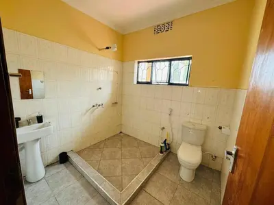 a bathroom with a toilet and a sink at Mlay Home in Arusha