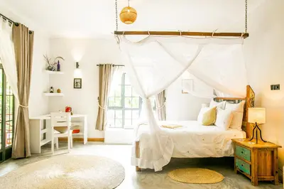a bedroom with a canopy bed and a desk at Treetops Villa in Arusha