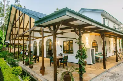 a pavilion with a table and chairs in front of a house at Treetops Villa in Arusha