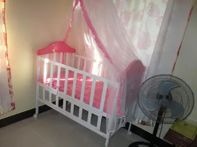 a crib in a room with a fan at Fanaka Safaris Campsite & Lodges in Mto wa Mbu