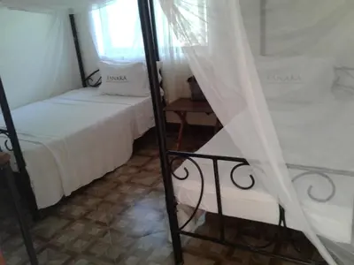 a small room with two beds and a window at Fanaka Safaris Campsite & Lodges in Mto wa Mbu