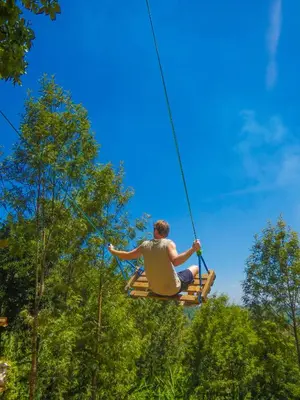 a man sitting in a chair on a rope swing at Makini Swing Adventure in Arusha