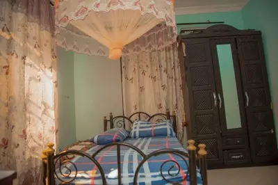 a bedroom with a bed with a curtain and a dresser at 3 Bedroom Appartment with Beautiful view of Kilimanjaro Mountain in Moshi