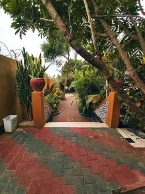 a red brick walkway with plants and trees at 3 Bedroom Appartment with Beautiful view of Kilimanjaro Mountain in Moshi
