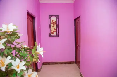a hallway with purple walls and a plant with white flowers at 3 Bedroom Appartment with Beautiful view of Kilimanjaro Mountain in Moshi