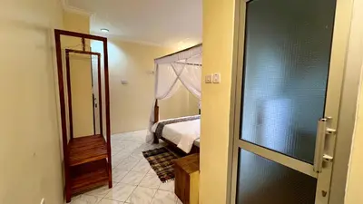 a door to a bedroom with a bed and a mirror at Ultra Home Apartment in Themi